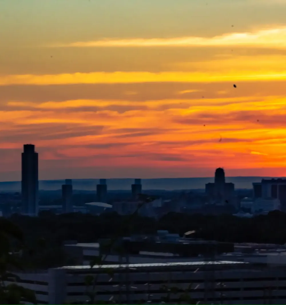 Orange and gold sunset above a distant city skyline