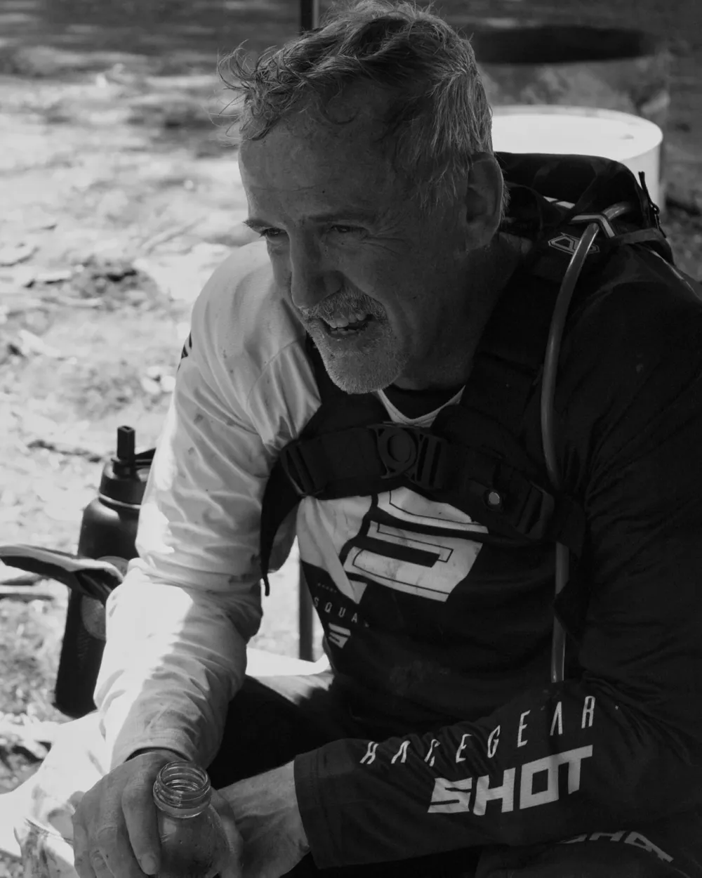 Black-and-white portrait of a motocross rider resting after a race